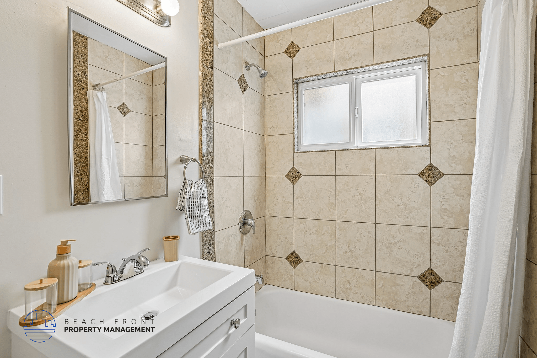 A bathroom with a tiled wall and a window.